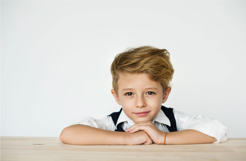 Young male child looking at camera in a white dress shirt